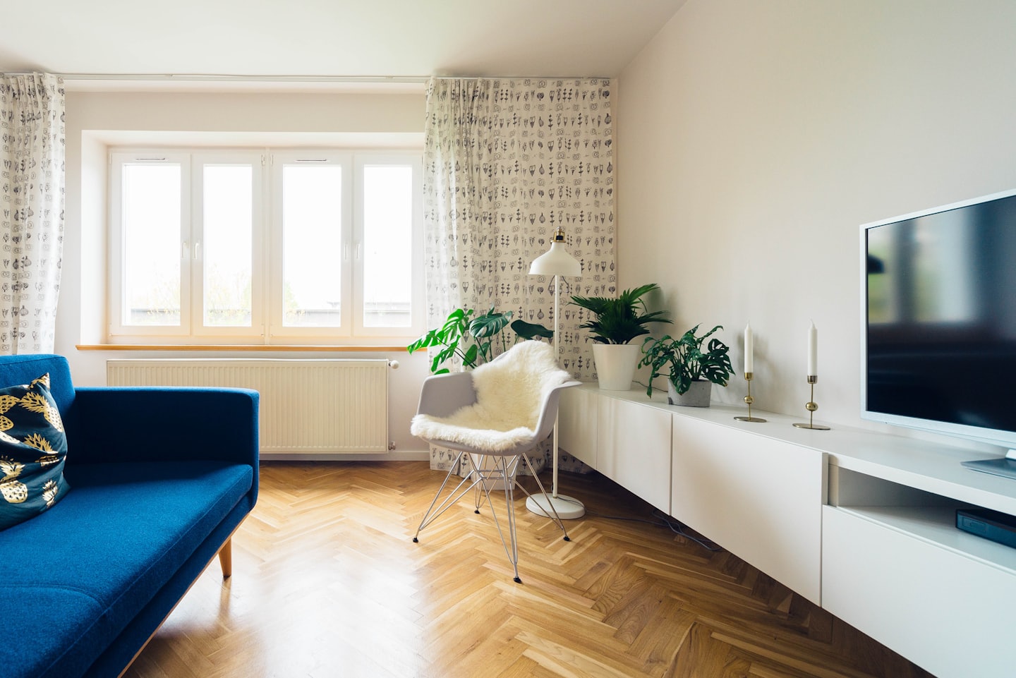 Modern living room with a blue sofa and white chair.